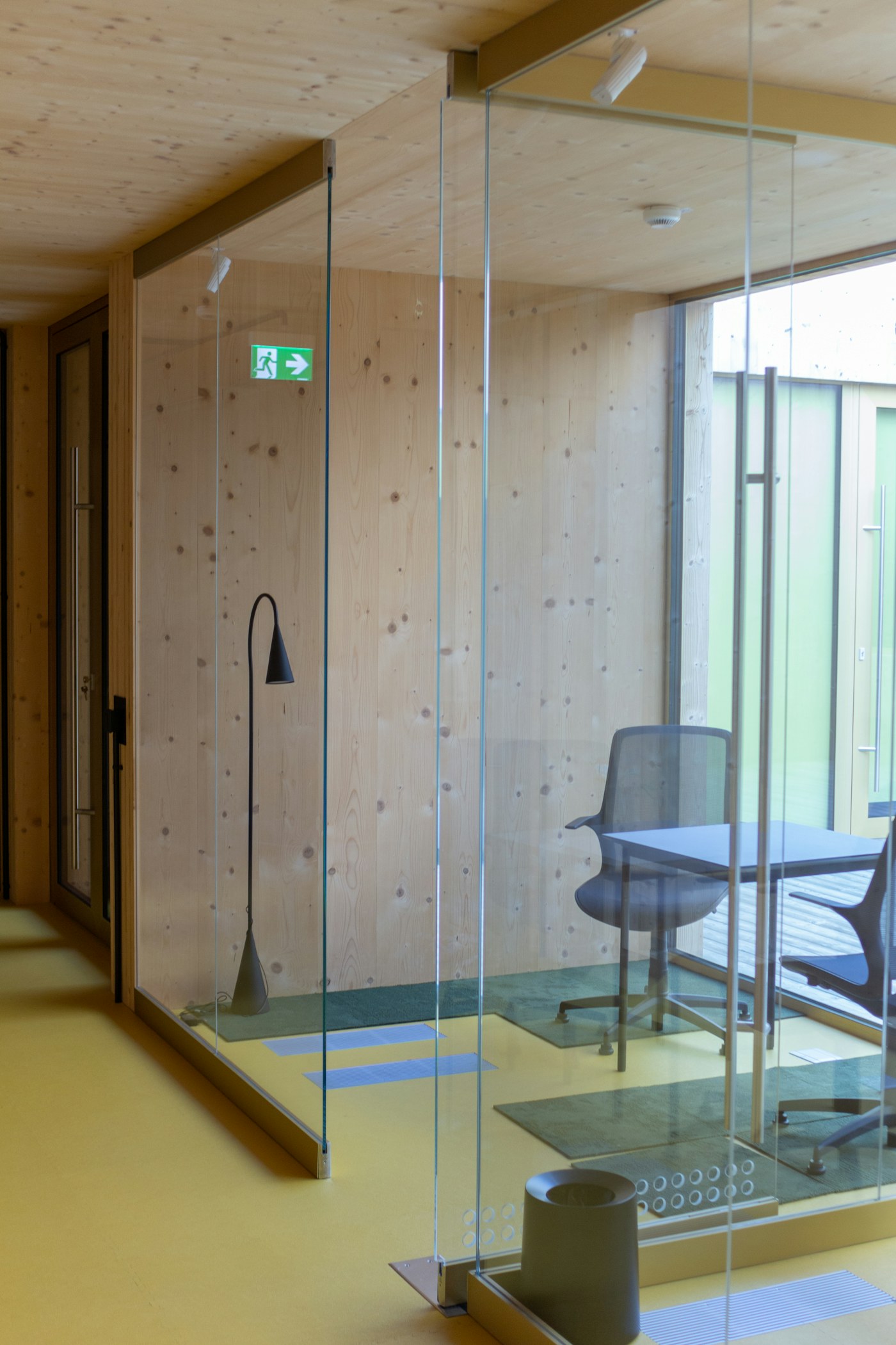 Illustrative small meeting room enclosed by glazed partitions